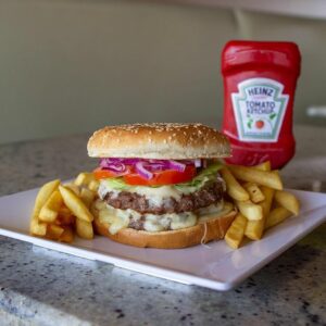 A burger with fries and ketchup on a plate.